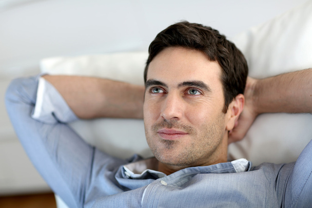 Man relaxing in sofa with arms behind head - Φωτογραφία, εικόνα