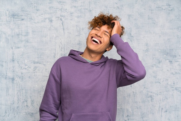 Молодой африканский американец смеется над гранж-стеной
 - Фото, изображение