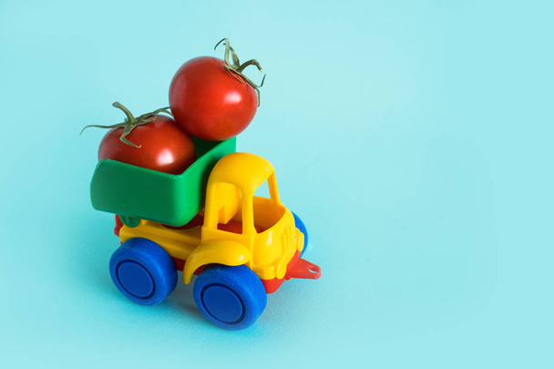 tomatoes natural vitamins are in the back of truck in a childrens toy car food delivery truck logistics - Foto, Imagem