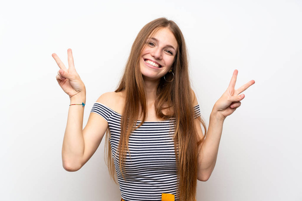 Giovane donna con i capelli lunghi oltre isolato muro bianco mostrando segno di vittoria con entrambe le mani
 - Foto, immagini