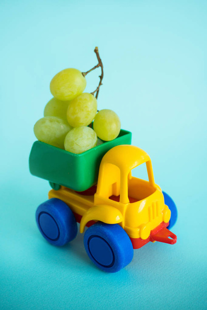 grapes natural vitamins are in the back of truck in a childrens toy car food delivery truck logistics - Fotoğraf, Görsel