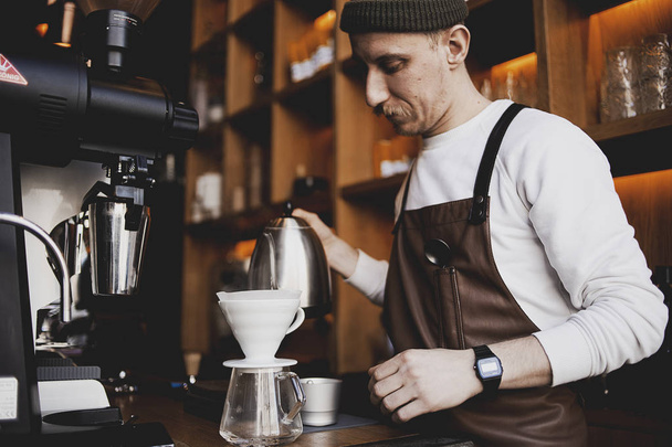 マンバリスタは、ドリップ醸造、濾過コーヒー、または注ぐ方法は、フィルターに含まれる焙煎、挽いたコーヒー豆の上に水を注ぐことを含む方法です。喫茶店で。ヴィンテージトーン - 写真・画像