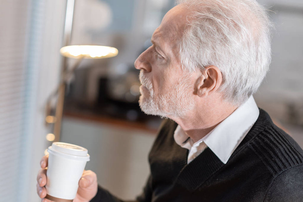 Задумчивый пожилой человек во время кофе-брейка
 - Фото, изображение