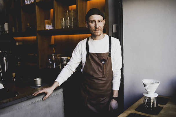 Portrait of bearded happy barista standing at trendy coffee shop, cafe - small business concept. Hipster barista man with beard. Own business, modern businessman  - Photo, Image