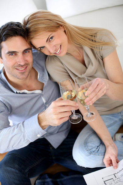 Cheerful couple celebrating with glass of sparkling wine - Фото, изображение