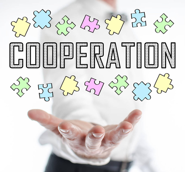 Concepto de cooperación levitando por encima de una mano
 - Foto, Imagen