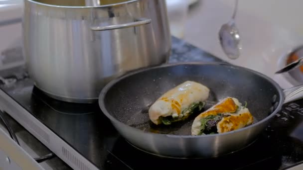 Chicken rolls with herbs frying in pan - Footage, Video