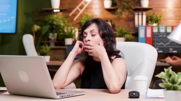 Втомлена бізнес-леді позіхає під час роботи на ноутбуці
 - Кадри, відео