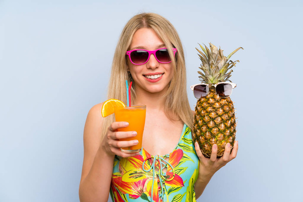 サングラスをかけたパイナップルを持った水着姿の若い女性 - 写真・画像