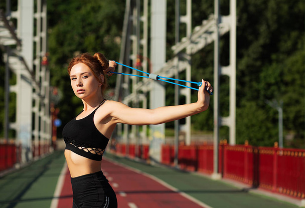 Gorgeous athletic woman doing stretching workout at the bridge i - Zdjęcie, obraz