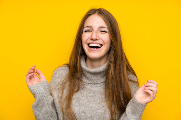 Молодая женщина с длинными волосами на желтом фоне смеется
 - Фото, изображение