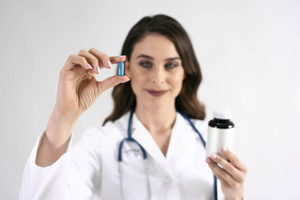 Arzt hält Pille in Studioaufnahme in der Hand  - Foto, Bild