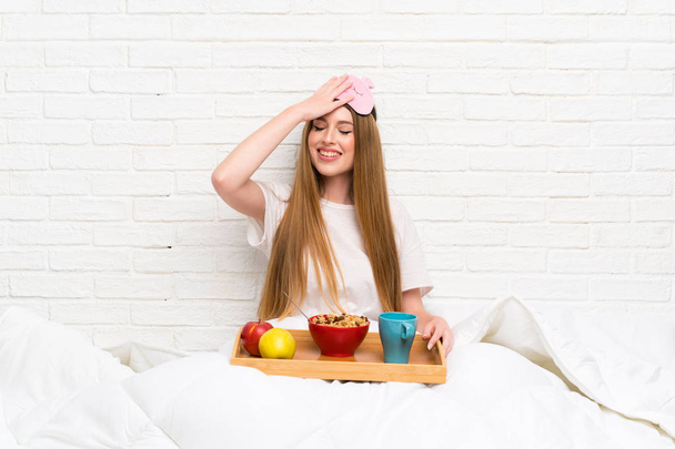 Young woman in dressing gown with breakfast laughing - Photo, Image
