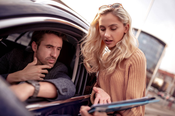 Verkäufer zeigt potenziellen Kunden im Autohaus Fahrzeug. - Foto, Bild