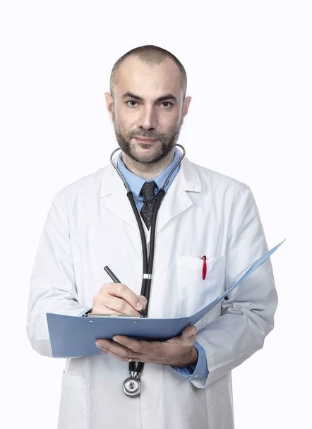 Porträt eines Arztes mit Laborkittel, der eine Diagnose schreibt. - Foto, Bild