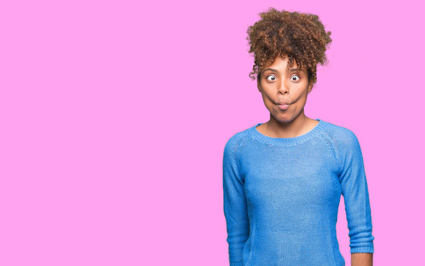 Beautiful young african american woman over isolated background making fish face with lips, crazy and comical gesture. Funny expression. - Photo, Image