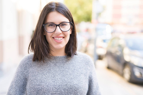 Giovane bella donna con gli occhiali sorridente fiducioso passeggiando per la strada della città
 - Foto, immagini