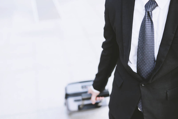 businessman in suits walking outside public transport building with luggage in rush hour. Business traveler pulling suitcase in modern airport terminal. baggage business Trip. Copy space , top view - Фото, зображення