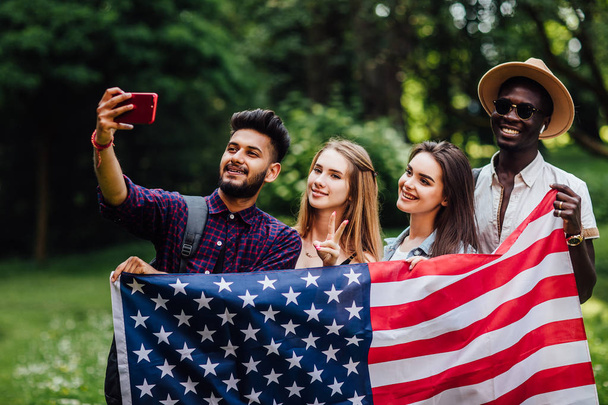 Pretty teenagers make a selfie with american flag, celebrating 4th july - Independence Day. - Foto, afbeelding