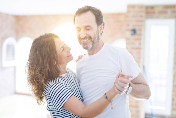 Casal sênior de meia-idade se mudando para uma nova casa, dançando e sorrindo feliz no amor com apartmant
 - Foto, Imagem