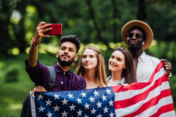 Focus at  teenagers make a selfie with american flag,on phone  celebrating 4th july - Independence Day. - Fotoğraf, Görsel
