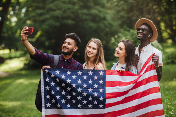 Bir grup genç, 4 Temmuz'u kutlayarak Amerikan bayrağıyla selfie çekti - Bağımsızlık Günü. - Fotoğraf, Görsel