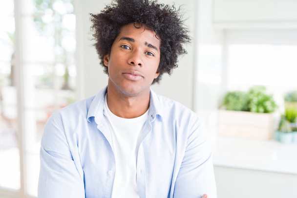Uomo afroamericano a casa Rilassato con espressione seria sul viso. Semplice e naturale con braccia incrociate
 - Foto, immagini