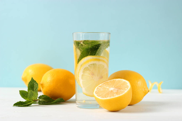 water with lemon on a colored background - Фото, изображение