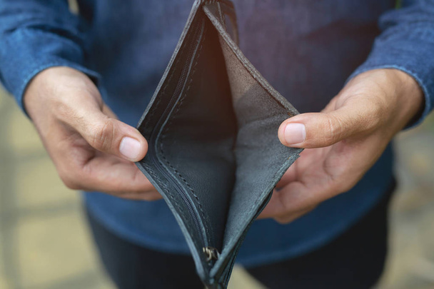 Üres pénztárca (nincs pénz) a kezében egy férfi. Költség-ellenőrzési költségek a szegénység fogalom - Fotó, kép