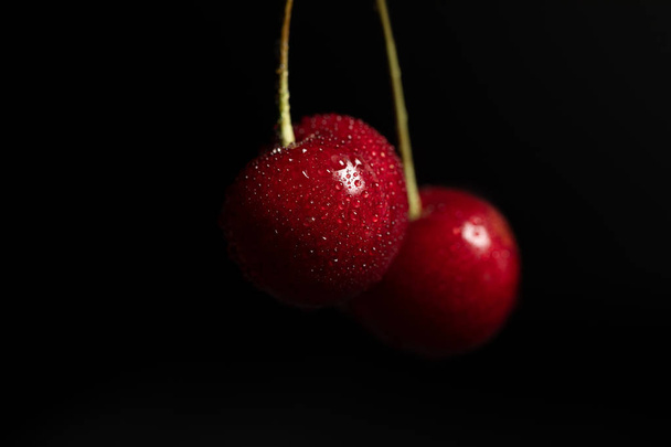 Vörös finom cseresznye vízcseppel izolált fekete - Fotó, kép