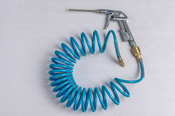 Luftkompressor Blaspistole mit aufgerolltem blauen Schlauch - Foto, Bild
