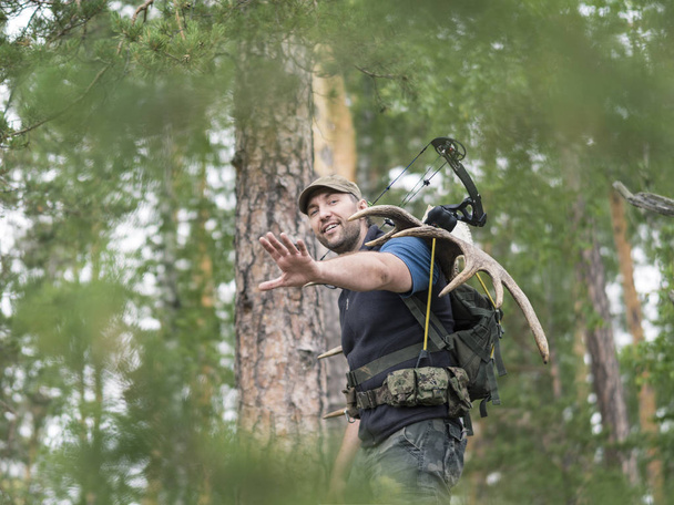 Vista de un cazador en el bosque lleva cuernos de alce en su espalda
 - Foto, imagen