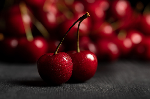 selective focus of red delicious sweet cherries on wooden table - Foto, Imagen