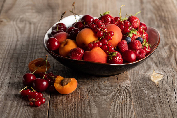 plate with mixed delicious ripe berries on wooden table - Photo, Image