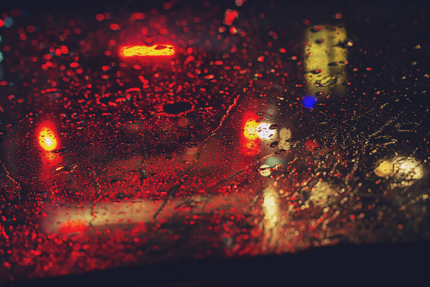 Akşam ları camın ön camına Yağmur Damlaları. şiddetli yağmurda sokak. Bokeh Kuyruk ışığı. yumuşak Odak. Lütfen dikkatli sür, kaygan yoldan. yumuşak odak. - Fotoğraf, Görsel