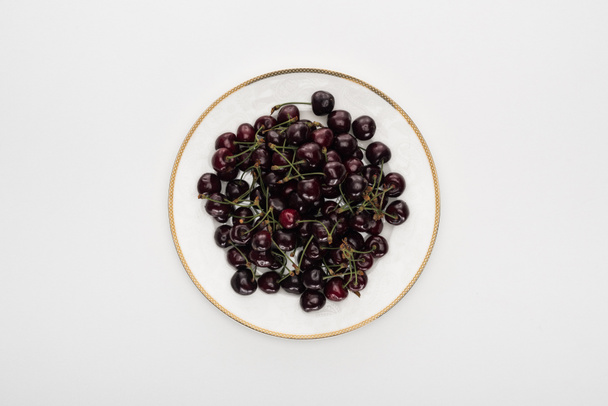 top view of red and sweet cherries on white plate  - Foto, afbeelding