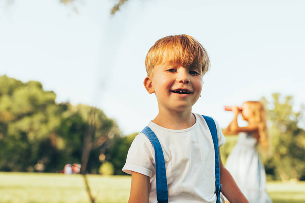 Joyful little boy playing in summer day in park. Happy child playing outdoors games on green grass. Childhood concept - Φωτογραφία, εικόνα