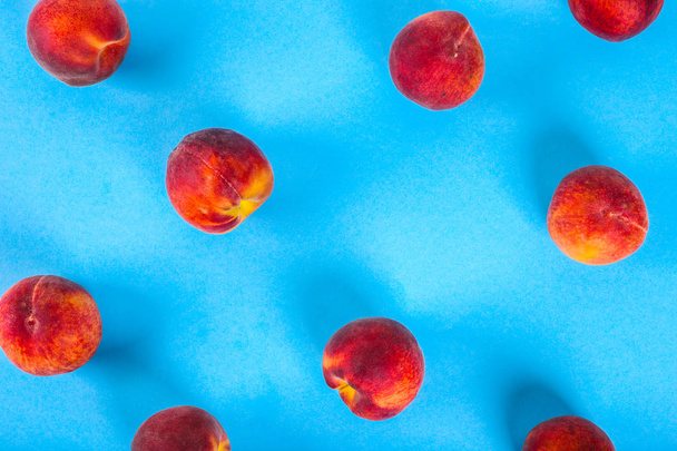 桃のパターン。青い背景に新鮮な果物のトップビュー。繰り返しの概念 - 写真・画像