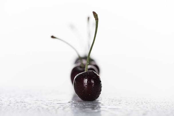 селективный фокус красной, цельной и спелой вишни, покрытой капельками
  - Фото, изображение