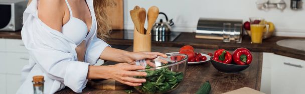 plano panorámico de chica sexy en sujetador blanco ensalada de cocina en la cocina
 - Foto, Imagen