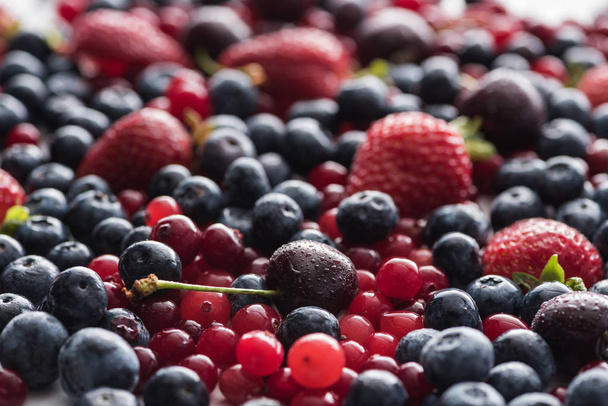 selective focus of red, fresh and ripe cranberries, strawberries, blueberries and wet cherries  - Fotó, kép