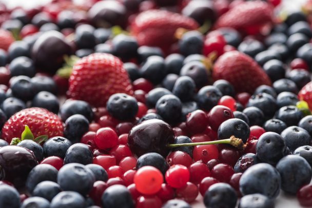 selective focus of red, fresh and ripe cranberries, strawberries, blueberries and cherries  - Valokuva, kuva