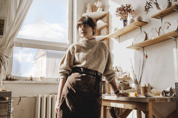 Professional female woman potter on her creative art studio in process creating and modeling new handmade sculpture clay dishes or something for interior. Creative profession, manufacture. Art space - Fotografie, Obrázek