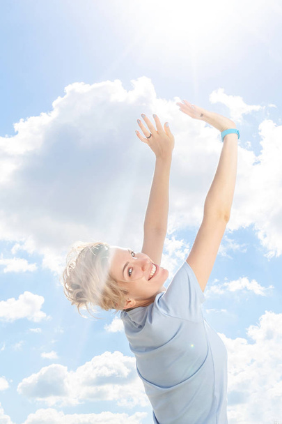 Young positive woman smiling with arms raised up - Photo, Image