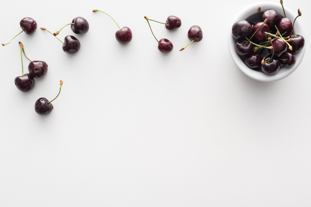top view of sweet and fresh cherries on bowl on white background  - Foto, Imagen