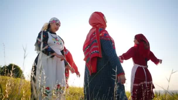 Lidé z tradičních ruských šatů chodí v kruhu, zpívají a baví se - Záběry, video