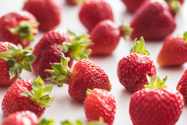 selective focus of whole and red strawberries on white background  - 写真・画像