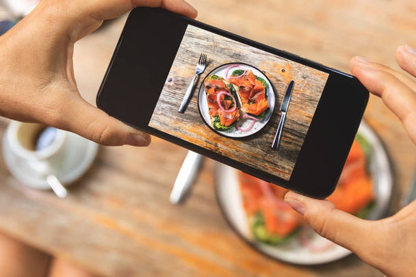 Image sur l'écran du smartphone de délicieux toasts avec un sal fumé
 - Photo, image