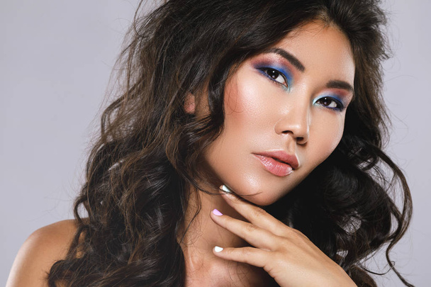 Молодая азиатка с красивыми вьющимися волосами и макияжем
 - Фото, изображение