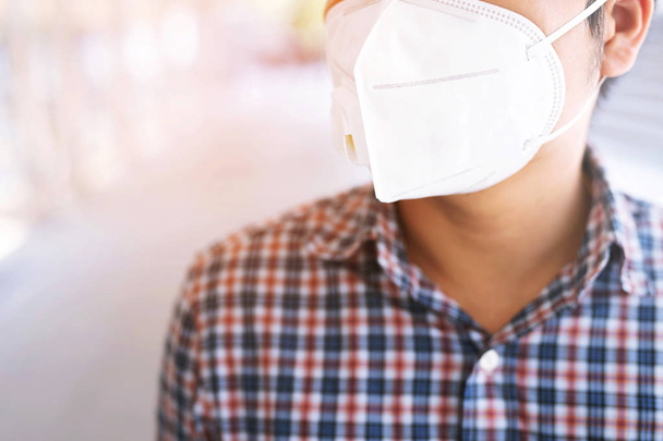 Portrait of man wearing facial hygienic mask nose outdoors. Ecology, air pollution car, Environmental and virus protection concept flu health against toxic dust covered the city of a health effect. - Photo, Image